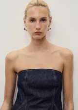 Top estilo corsé de mezclilla azul oscuro, sin mangas, con escote palabra de honor y corte peplum.