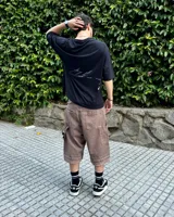 Bermuda de corte baggy color marrón con efecto gastado (lavado vintage), doble carpintero y detalle artesanal visible en el bajo. Incluye un cordón extra confeccionado en la misma tela.