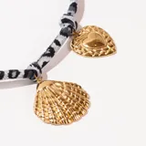 Collar corto con cordón estampado animal print en tonos grises y dijes colgantes dorados en forma de corazón, caracol y concha.