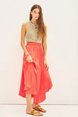 Falda midi de corte fluido con cintura elástica fruncida, confeccionada en tejido satinado de color coral.