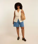 Bermuda de jeans de algodón, color azul medio, de corte amplio y largo hasta la rodilla. Presenta tiro alto con ajuste elástico interno en la cintura y bolsillos frontales.