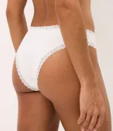 Kit de dos bombachas tipo bikini confeccionadas en algodón y elastano, de cintura media con encaje en las aberturas de las piernas y un pequeño moño frontal decorativo. Una pieza en tono crudo y otra en rosado.