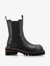 Bota de cuero premium color negro, de diseño minimalista estilo Chelsea con elásticos laterales y tiradores superiores. Posee una suela track de goma con plataforma y taco cuadrado con detalle de madera.