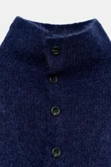 Jersey de punto de color azul marino con cuello perkins y cierre frontal con botones. Presenta un diseño de manga larga con hombros caídos y textura suave.