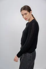 Sweater azul marino de punto calado, confeccionado en 100% baby alpaca, de manga larga y cuello redondo.