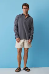Buzo de friza de algodón color gris oscuro, con cuello polo y cierre frontal de botones, de manga larga y calce relajado.