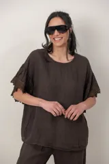 Blusa de lino color chocolate, de corte holgado, con escote redondo y mangas cortas amplias con detalles de volados y puntilla bordada.