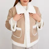 Campera gamulán corta color beige con forro y detalles de corderito sintético blanco, cuello solapa amplio, cierre frontal de botones y dos bolsillos frontales con solapa.