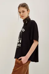 Remera de algodón color negro, con cuello redondo y mangas cortas. Presenta un estampado frontal con tres guitarras y la inscripción 'Rock Hard Forever' en color crema.