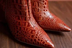 Botas cortas color marrón con estampado de cocodrilo, punta fina y taco de 8.5 cm.