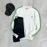 Buzo deportivo blanco con mangas largas y cuello redondo. Presenta una franja vertical verde en los hombros y un logo pequeño bordado en el pecho.