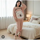Conjunto de pijama de dos piezas confeccionado en tela de plush suave y abrigada. Incluye una remera de manga larga con diseño estampado de Totoro y pantalón largo a juego con puños en contraste.