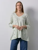 Blusa marca Ruby Rd con estampado abstracto en tonos verde y blanco, escote en V y mangas tres cuartos. Presenta apliques de botones en los laterales.