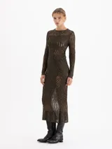 Top de mangas largas y cuello redondo confeccionado en tejido de punto con hilos metalizados. Presenta un diseño de calce al cuerpo con una trama calada que genera transparencias orgánicas.