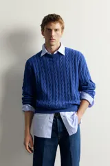 Sweater de punto verde con diseño de trenzas, cuello redondo y manga larga, de corte regular fit y acabados en rib.