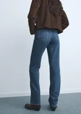 Pantalón de jean de corte recto y tiro medio, con cierre frontal de cremallera y botón, y diseño clásico de cinco bolsillos.