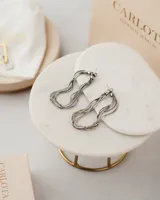 Aros colgantes de acero quirúrgico plateado, con diseño de múltiples cadenas entrelazadas.