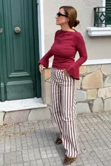 Remera de algodón color bordó, con mangas largas estilo oxford que presentan un diseño acampanado en los puños y escote bote.