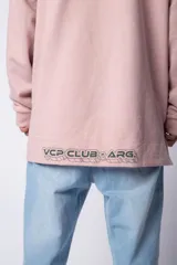 Buzo tipo canguro con capucha, confeccionado en una combinación de algodón rústico y microfibra. Presenta un diseño bicolor en tonos rosado y verde militar, con bolsillo frontal tipo canguro en contraste, cordones ajustables y estampa personalizada en el frente.