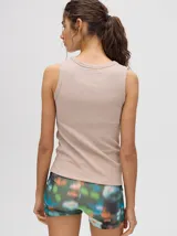 Musculosa crop de algodón, color terracota, con cuello redondo y puños acanalados. Presenta un pequeño logo bordado centrado en el pecho.