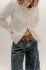 Faja de cuero color tostado con diseño de tachas metálicas circulares grabadas y cierre frontal con hebilla.