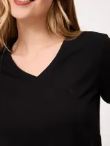 Remera básica de manga corta y cuello en V, de color negro, con un pequeño detalle bordado en el pecho.