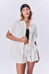 Camisola color arena de mangas cortas con botones.