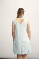 Vestido corto sin mangas, color celeste claro, con escote en V y costuras visibles en contraste.