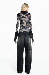 Pantalón jean de mujer con silueta baggy, lavado negro con efecto desgastado y detalles sutiles de pintura.