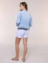 Camperita de denim clásico con lavado claro, cuello camisero, cartera frontal con botones metálicos y bolsillos superiores con solapa. Presenta mangas largas con puños abotonados y costuras estructuradas.