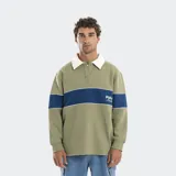 Buzo de estilo rugby con cuello camisero en contraste de color blanco. Presenta una franja horizontal azul en el pecho con el logo de la marca estampado y diseño de manga larga con puños elásticos.