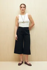 Pantalón capri negro acampanado de algodón con inspiración cargo, corte amplio y bolsillos laterales.