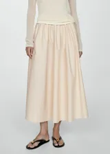 Falda midi de corte evasé confeccionada en algodón, con diseño de tablas y cierre lateral invisible.
