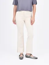 Pantalón jean color blanco, de corte recto y tiro alto, con terminación desflecada.