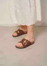 Sandalias marrones de tiras cruzadas, con hebillas doradas ajustables y suela de corcho.
