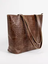 Cartera tote de cuero natural color beige, con doble asa larga para hombro y cierre superior con broche.
