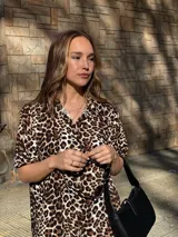 Camisola larga de muselina con estampado animal print de leopardo. Presenta cuello camisero, mangas cortas y aberturas laterales en el ruedo.