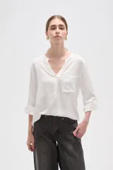 Blusa de viscosa color blanco, con cuello en V, manga 3/4 y bolsillo frontal en el pecho.