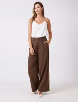 Pantalón tipo palazzo de corte ancho y tiro alto, confeccionado en tejido sastrero fluido. Presenta una cintura estructurada con doble abotonadura frontal, pinzas delanteras y cintura elástica en la parte posterior. Incluye bolsillos laterales funcionales.