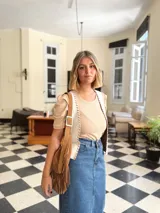 Cartera bandolera de cuero color camel con flecos largos en la parte inferior.