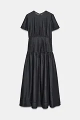 Vestido midi de denim color negro con cuello redondo y manga corta. Presenta un diseño con cintura entallada tipo bustier y falda con corte evasé. Cierre posterior con cremallera.