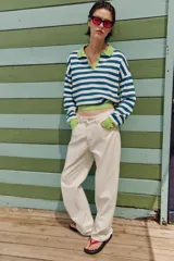 Sweater de punto a rayas horizontales en azul y blanco, con cuello polo verde lima, escote en V y detalles en verde lima en los puños y el borde inferior.