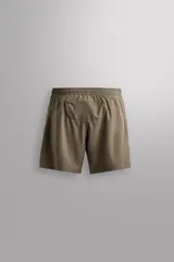 Short deportivo Zara Athleticz de color marrón, confeccionado en tejido técnico ligero y elástico con forro interior. Cuenta con cintura elástica ajustable con cordón, bolsillos frontales, bolsillo trasero con cierre de cremallera, bajo con aberturas laterales y detalle de logo estampado en la pierna.