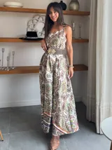 Vestido largo de satén con estampado de mandalas en tonos blanco, verde, marrón y naranja. Tiene breteles finos y corte imperio con cinturón marrón con hebilla dorada.