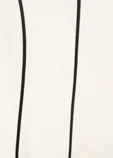 Vestido midi color crudo con tirantes anchos y escote cuadrado. Presenta ribetes negros en cuello, sisas y costuras verticales.