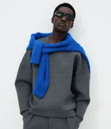 Buzo de cuello redondo y mangas largas con corte oversized. Confeccionado en tejido scuba de estructura firme, presenta un recorte horizontal en el frente que aporta un detalle contemporáneo y minimalista.