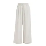 Pantalon Adidas de mujer, de corte ancho y estilo deportivo, color beige con las icónicas tres tiras blancas laterales y logo de la marca bordado.
