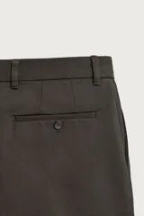 Pantalón straight fit color marrón oscuro, confeccionado en tejido compacto de algodón con estructura twill, bolsillos frontales, bolsillos traseros de vivo con botón y cierre frontal con cremallera y botón.