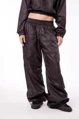 Pantalón wide leg impermeable negro con estampado de logos. Tiene bolsillos laterales ocultos, bolsillos en piernas y en posterior. Tiene tanca en ruedo para ajustar.