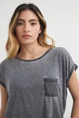 Remera gris de corte holgado con bolsillo en el pecho y mangas cortas con dobladillo.